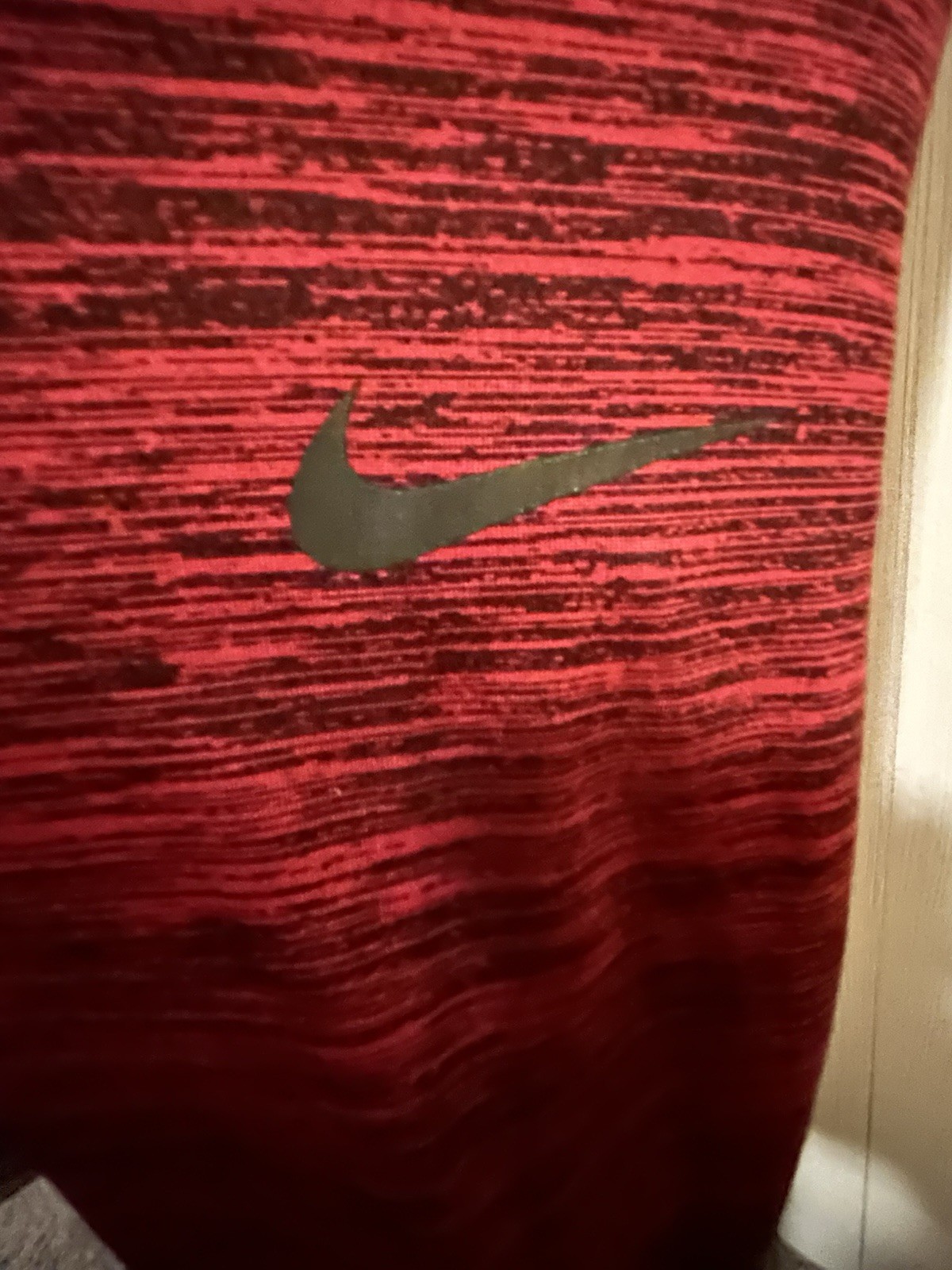 red Nike Dri-FIT training shirt With a black swoosh logo and heathered pattern gallery