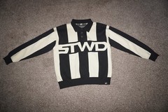 black and off-white long-sleeve knit polo sweater. It features bold vertical